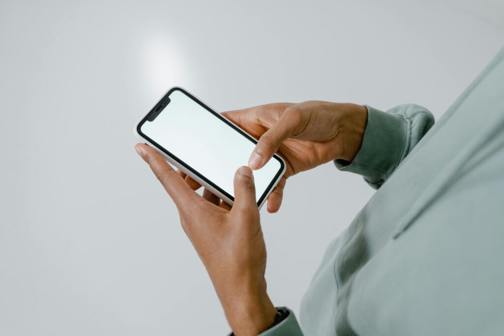 Person in hoodie interacting with a modern smartphone screen.