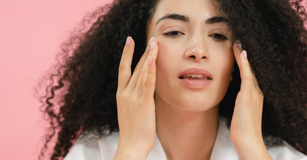 A young woman with curly hair applies skincare products, emphasizing a healthy facial routine.